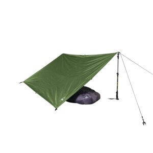 Green tarp pitched as a lean-to over a purple sleeping bag, supported by an adjustable trekking pole and tied-off guy lines on a white background