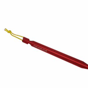 Red anodised aluminium tent peg with a pointed tip and embossed TERRA-NOVA.CO.UK logo, fitted with a short yellow cord loop and shown on a black background.