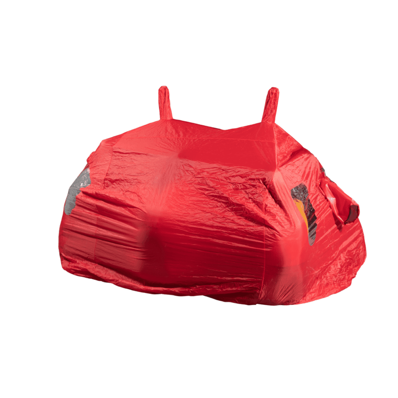 A small car tightly draped in bright red stretch fabric, with outlines of headlights, side mirrors and two short upright roof loops showing through the taut material on a plain white background.