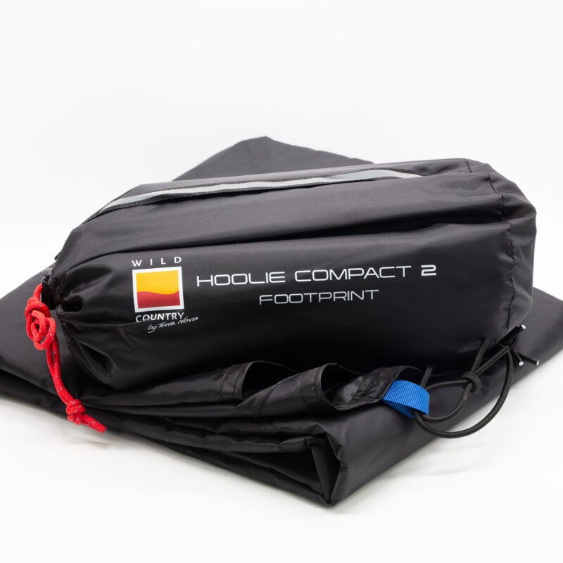 Black folded tent footprint in its storage bag labelled HOOLIE COMPACT 2 FOOTPRINT with a Wild Country logo, red drawcord and blue attachment loop on a white background
