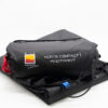 Black folded tent footprint and cylindrical stuff sack on a white background, labelled 'NORTE COMPACT 1 FOOTPRINT' with a Wild Country by Terra Nova logo, red drawcord and blue attachment tab visible.