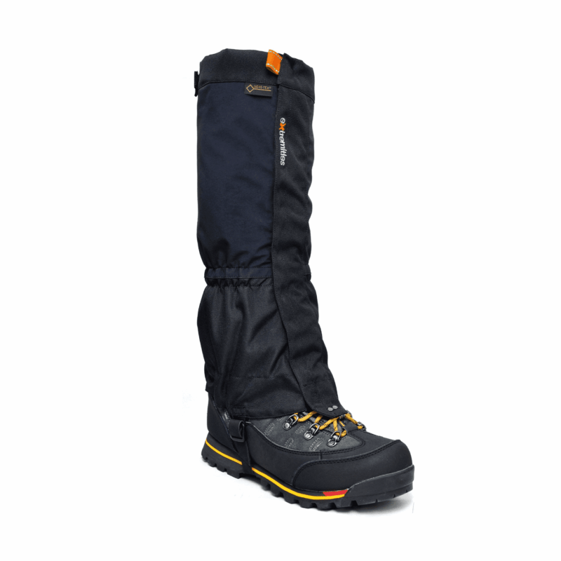 Tall black waterproof gaiter fitted over a sturdy black hiking boot with yellow lace accents and yellow-and-red sole trim, metal eyelets and deep lug tread on a white background.