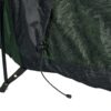 Close-up of a green and black tent base showing a black support pole through a stitched fabric strap with a metal grommet and a loose drawcord ending in a plastic toggle.