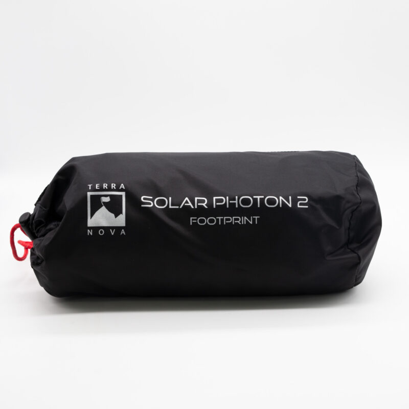 Black cylindrical stuff sack bearing the Terra Nova logo and white text 'SOLAR PHOTON 2 FOOTPRINT', cinched closed with a red drawcord.