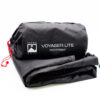 Folded black Terra Nova Voyager Lite footprint with its cylindrical stuff sack showing the white logo and text 'VOYAGER LITE FOOTPRINT' and a red drawcord at one end.