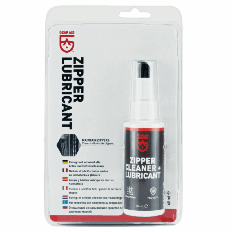 Blister-packaged 60 ml Gear Aid zipper cleaner and lubricant spray bottle with a grey label and red logo, shown on a backing card featuring bold vertical 'ZIPPER LUBRICANT' text.