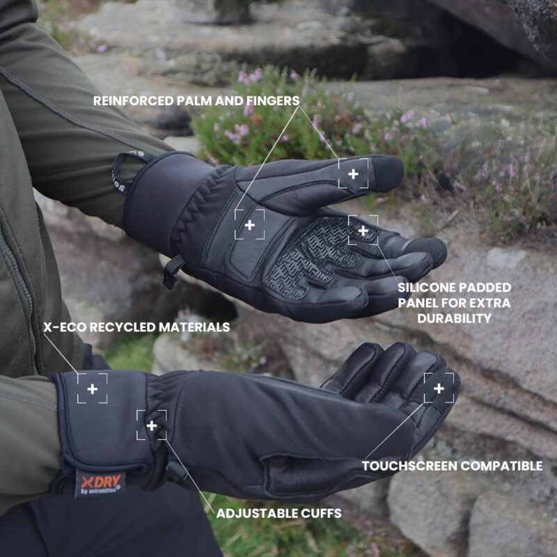 Black insulated outdoor gloves shown palm-up and palm-down on a rocky background with annotated labels highlighting reinforced palm and fingers, silicone-padded panel for durability, touchscreen compatibility, adjustable cuffs and X‑ECO recycled materials with an XDRY tag visible.