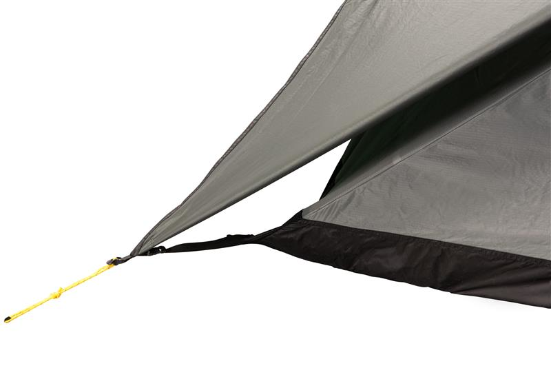Close-up of a grey tent rainfly corner with a black hem and a taut yellow guyline clipped to a black strap and tensioner.