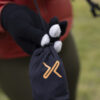 Person holding a compact, black pouch with an orange logo, featuring gloves designed for outdoor activities. The gloves have a unique design with white accents on the fingertips.